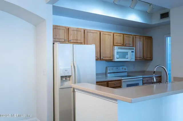 a kitchen with stainless steel appliances a refrigerator sink and cabinets