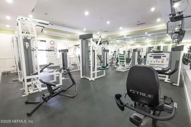 a room with gym equipment and glass windows