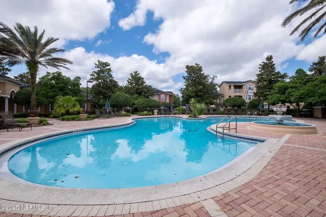 a view of a swimming pool with outdoor seating and plants