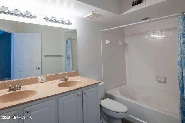 a bathroom with a granite countertop sink a toilet and bathtub