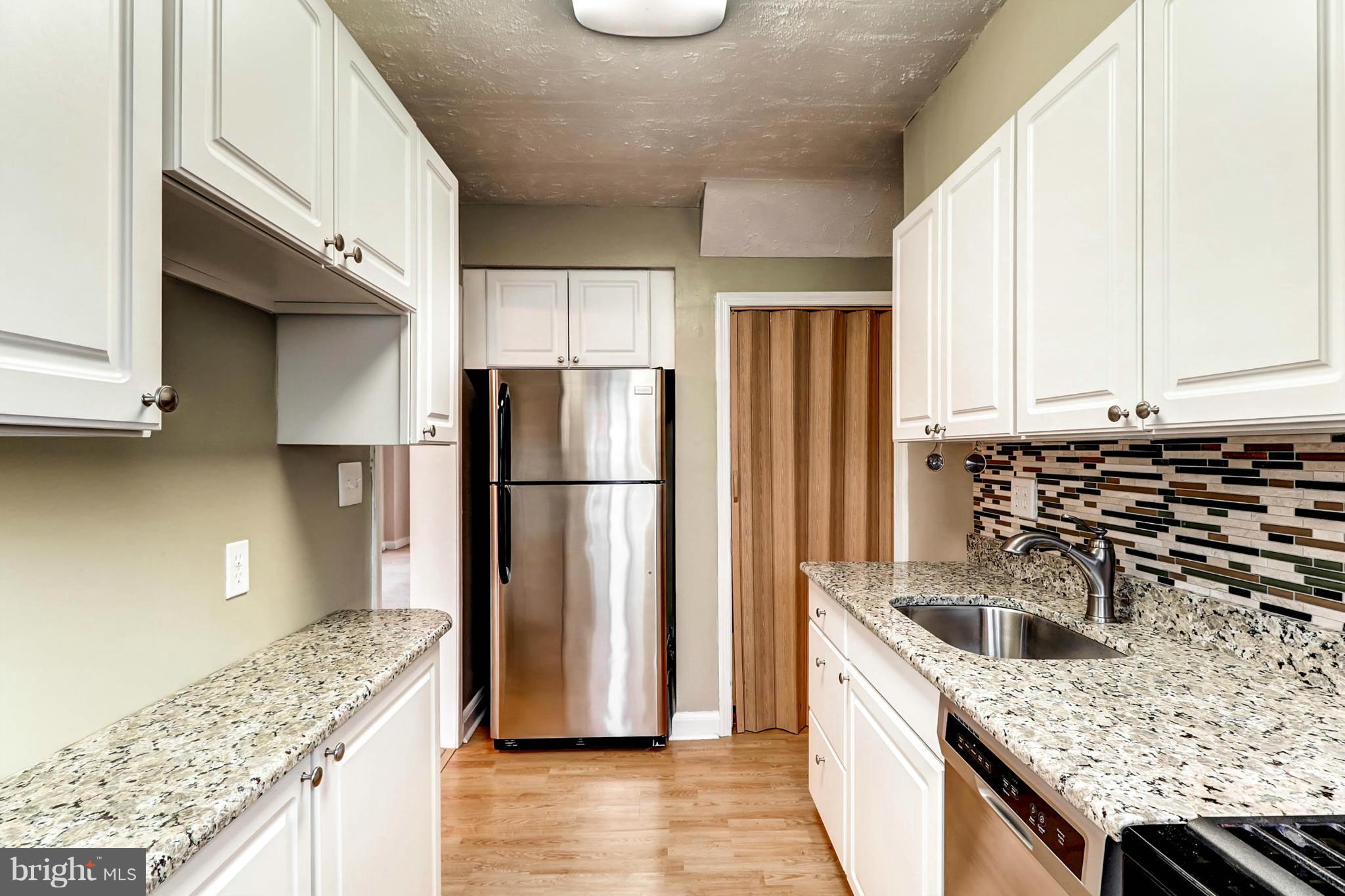 2102 Redthorn Road Baltimore, MD 21220 - Photo 4 of 30 a kitchen with granite countertop a sink a stove and refrigerator