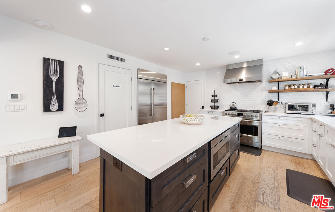 5317 Pacific Avenue Marina del Rey, CA 90292 - Photo 16 of 41 a large white kitchen with a stove top oven a sink dishwasher and a refrigerator with wooden floor