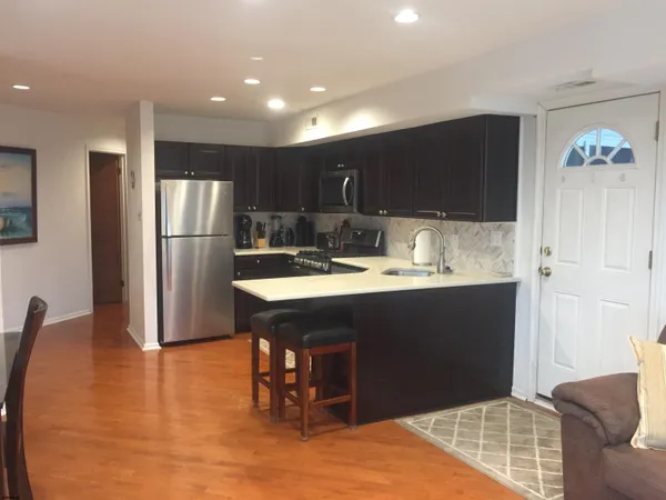 a kitchen with kitchen island a sink stainless steel appliances and cabinets