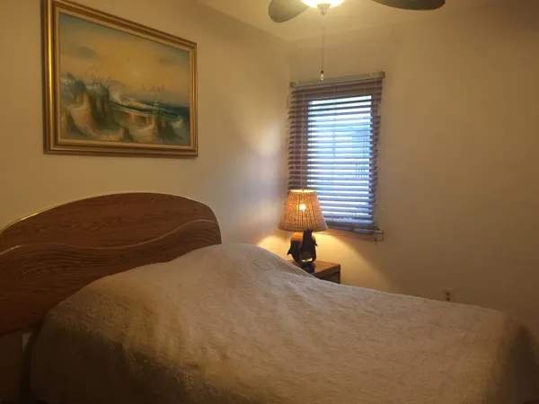 a bedroom with a bed and a painting on the wall