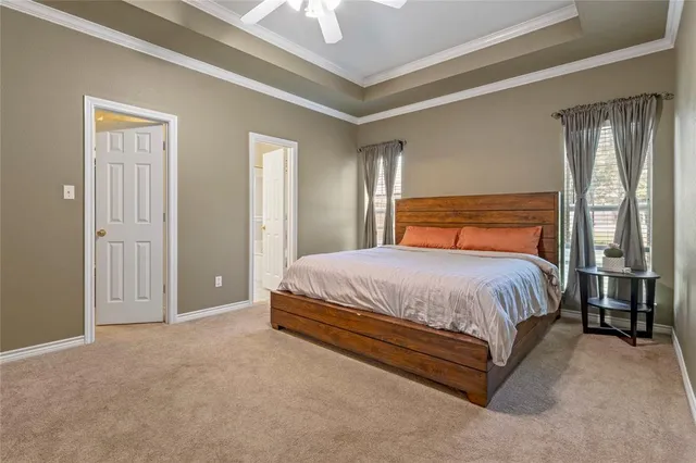 a bed sitting in a spacious bedroom next to a window