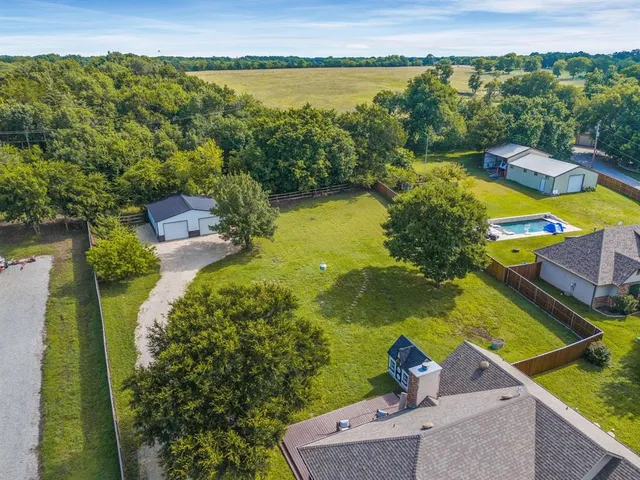 an aerial view of residential houses with outdoor space and swimming pool