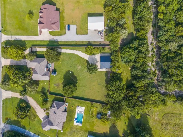 an aerial view of a house with a garden and lake view