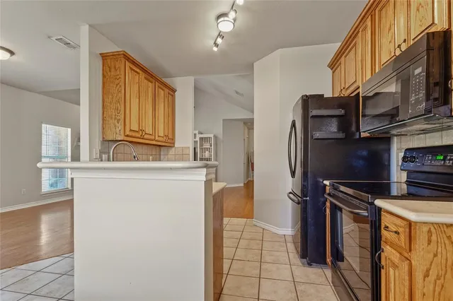 a kitchen with stainless steel appliances a refrigerator and a stove top oven