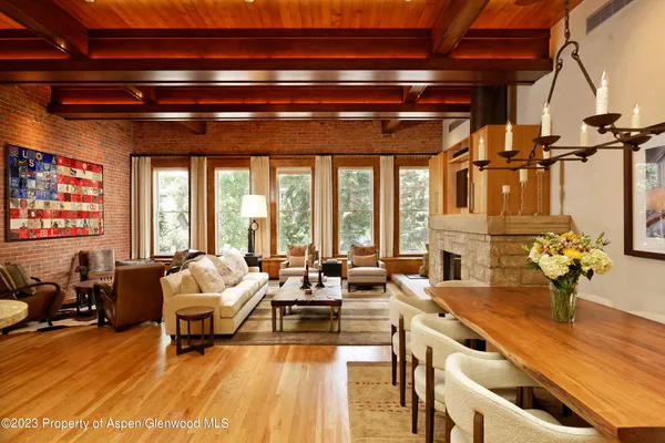 a living room with furniture a fireplace and large windows