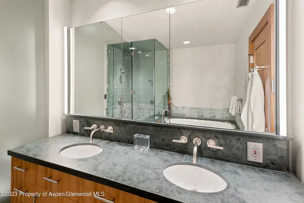 a bathroom with a granite countertop double vanity sink and a mirror