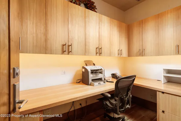 a view of a workspace with furniture and a window