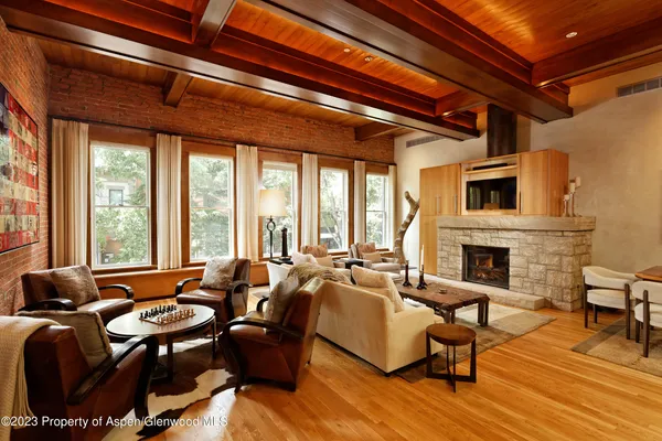 a living room with furniture fireplace and large windows