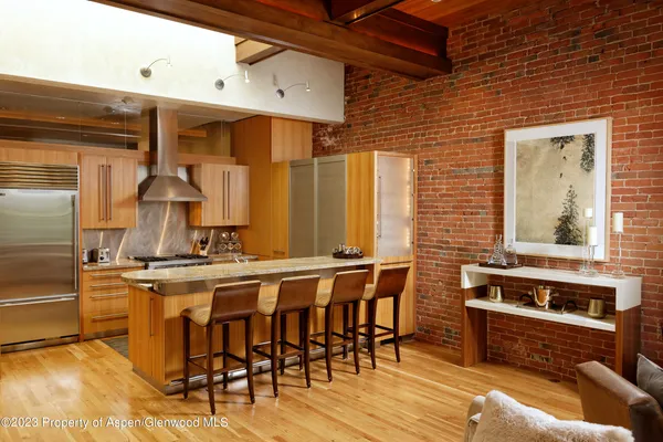 a kitchen with stainless steel appliances a stove a table and chairs