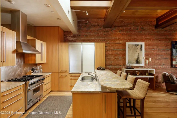 a kitchen with stainless steel appliances kitchen island granite countertop a stove a sink and a refrigerator