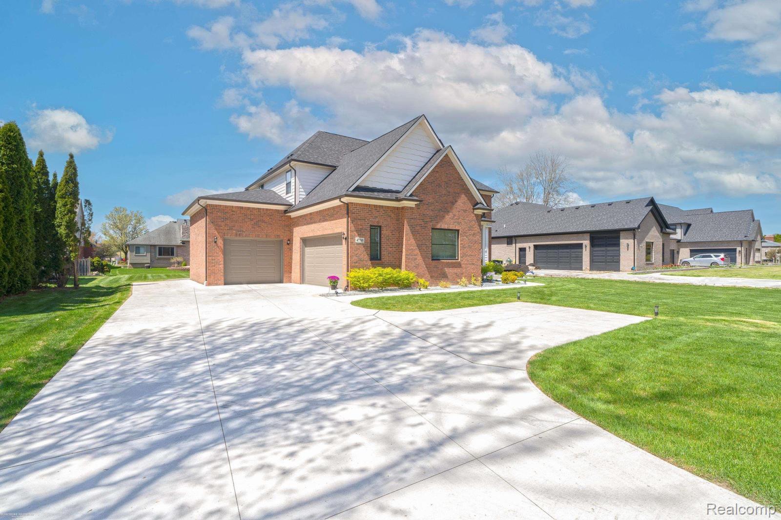 47705 Card Road Macomb, MI 48044 - Photo 3 of 53 Brick and siding exterior featuring a multi-car garage with individual doors
