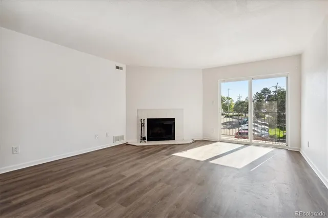a view of an empty room with a fireplace and a window