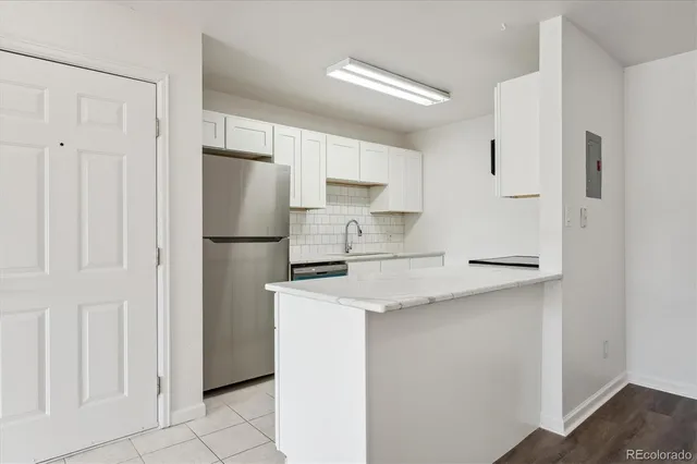 a kitchen with stainless steel appliances granite countertop white refrigerator stove a sink and white cabinets