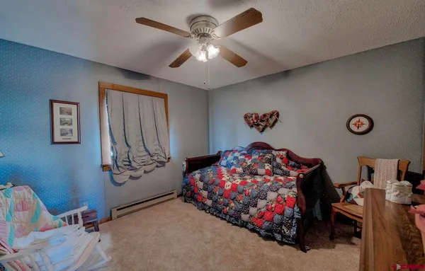 a bedroom with a bed window and dresser