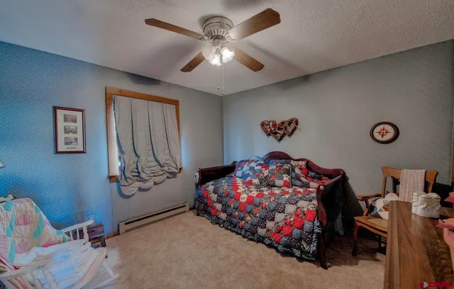 a bedroom with a bed window and dresser