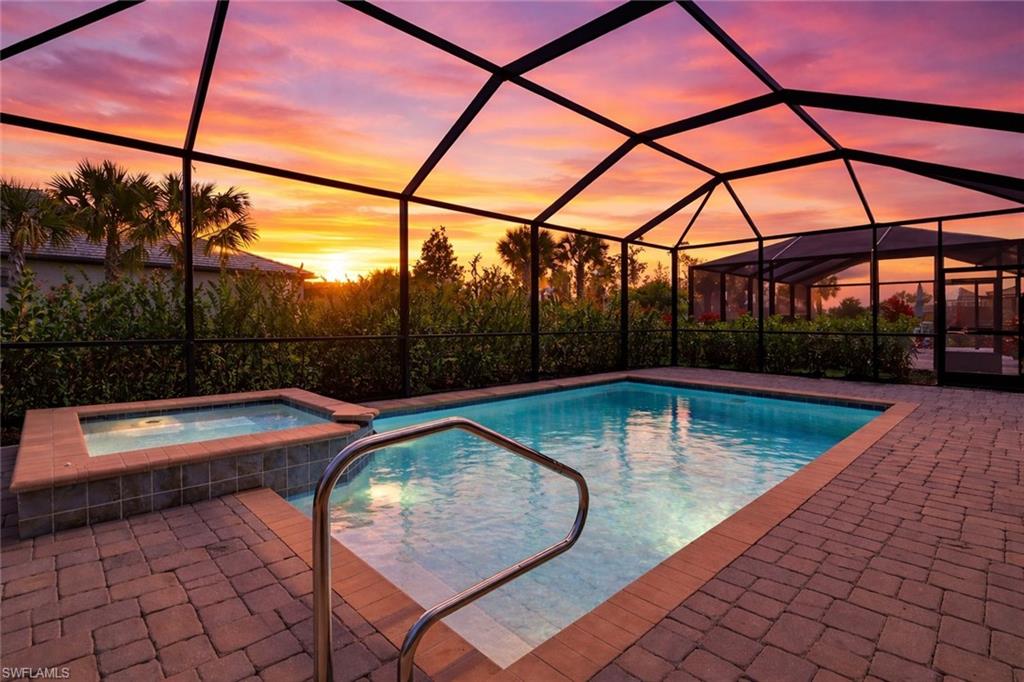 Combined pool / hot tub with a sunroom, a lanai, and a patio
