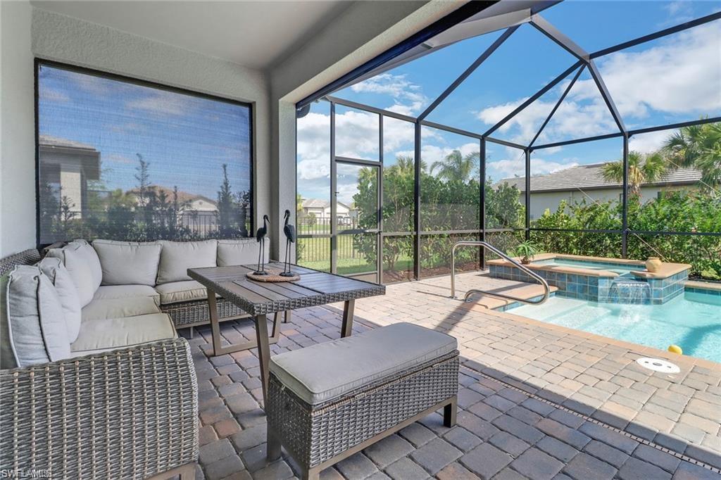 17609 Ashcomb Way Estero, FL 33928 - Photo 17 of 40 View of patio / terrace with a sunroom, a pool with connected hot tub, outdoor furniture, and glass enclosure