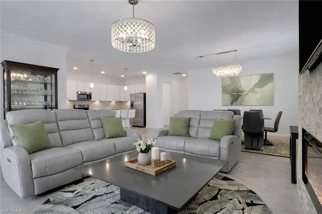 17609 Ashcomb Way Estero, FL 33928 - Photo 5 of 40 Living area featuring suspended lighting, ornamental molding, and concrete flooring