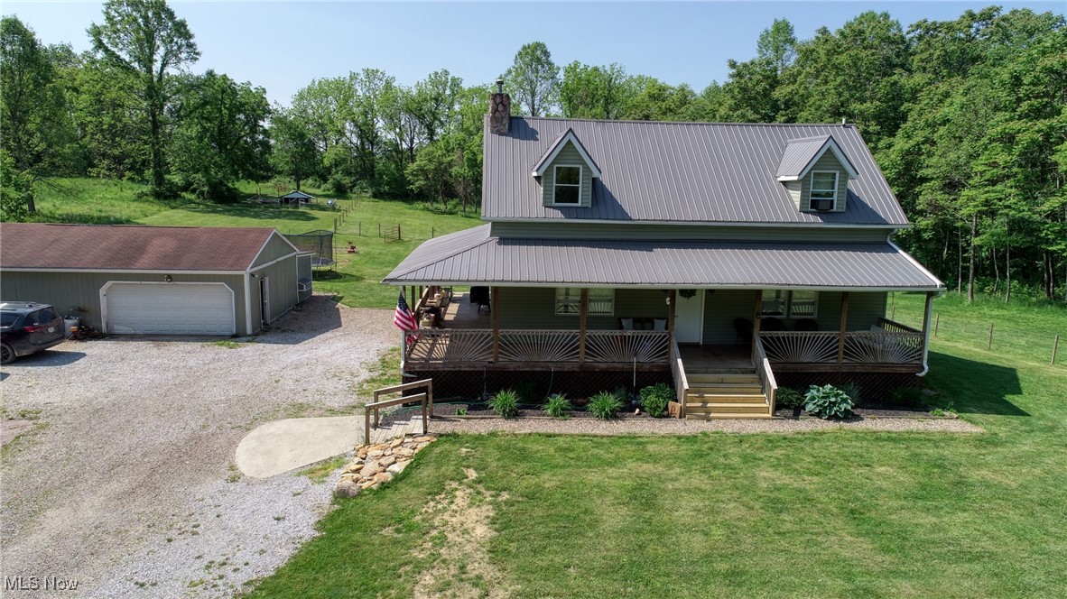 8498 Euga Road Newcomerstown, OH 43832 - Photo 2 of 49 View of front of house with gravel driveway, a porch, a front lawn, and an outdoor structure