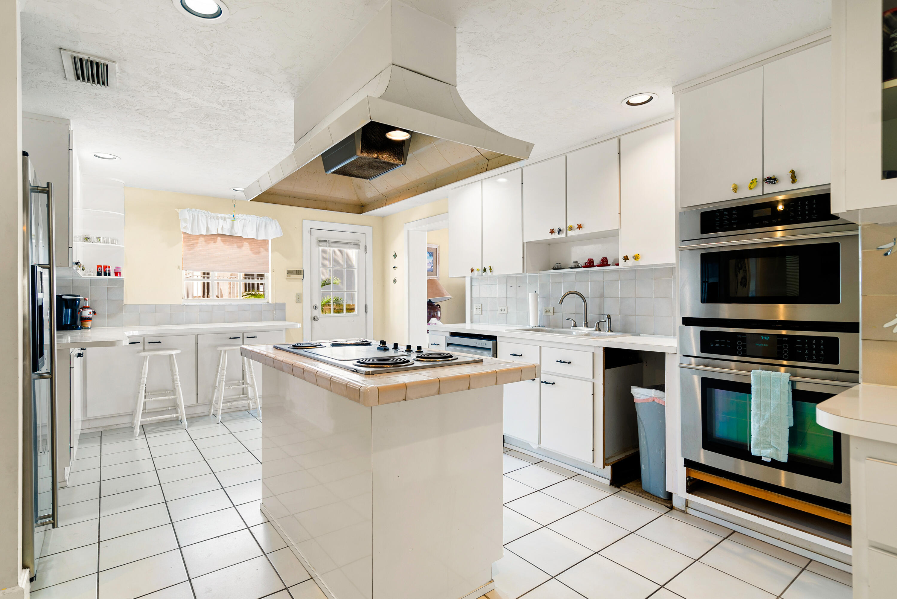 239 Atlantic Boulevard Key Largo, FL 33037 - Photo 14 of 50 a kitchen with white cabinets stainless steel appliances and sink