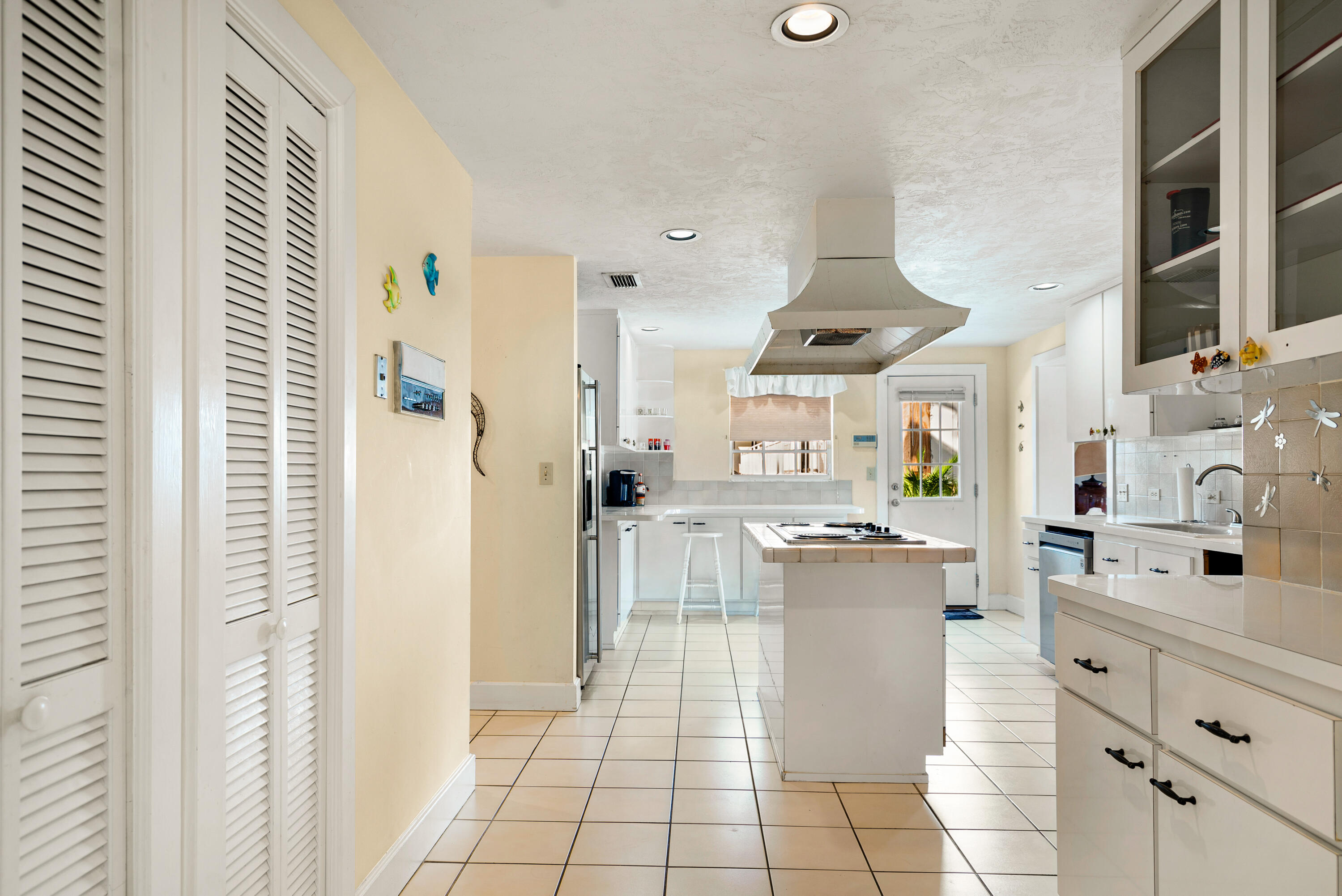 239 Atlantic Boulevard Key Largo, FL 33037 - Photo 16 of 50 a kitchen with stainless steel appliances kitchen island granite countertop a refrigerator and a stove top oven