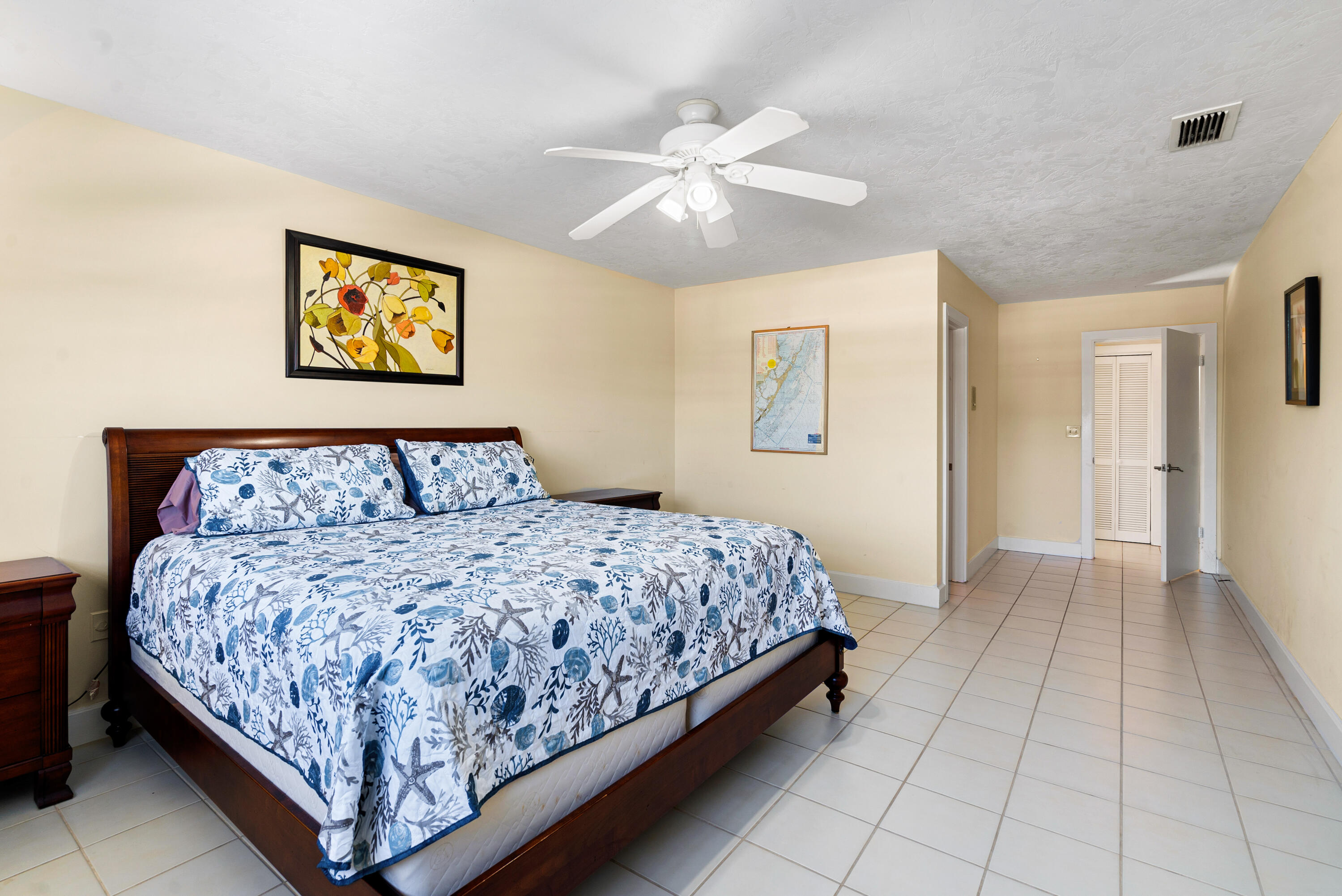 239 Atlantic Boulevard Key Largo, FL 33037 - Photo 27 of 50 a bedroom with a large bed and a chandelier