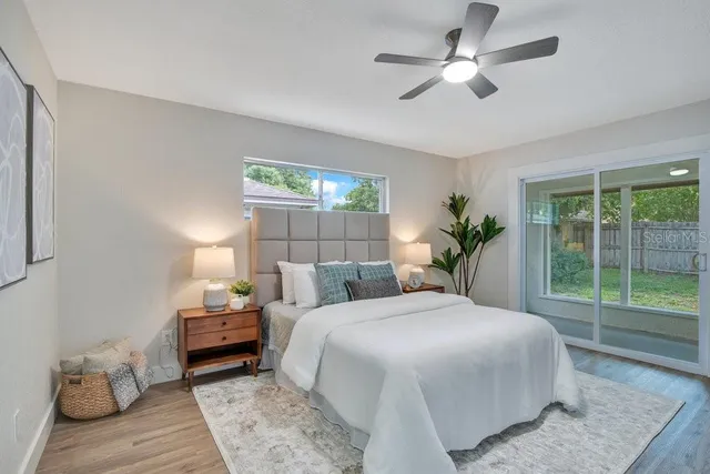 a bedroom with a large bed and a chandelier fan