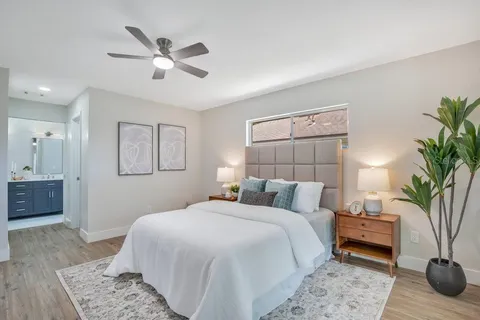 a bedroom with a large bed and a chandelier