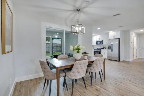 a view of a dining room with furniture a chandelier and wooden floor