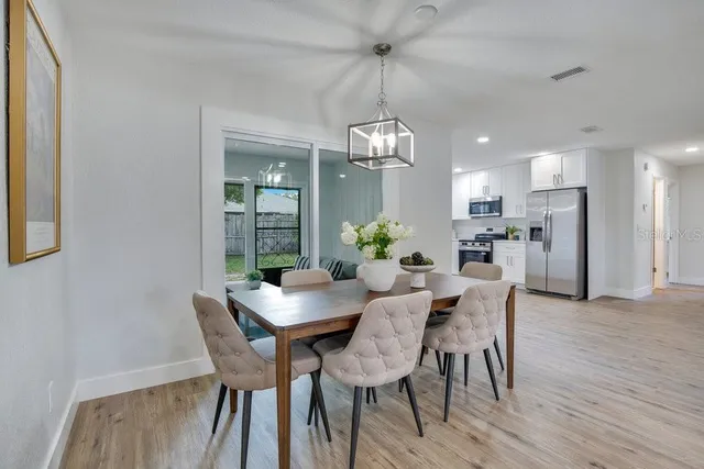 a view of a dining room with furniture a chandelier and wooden floor