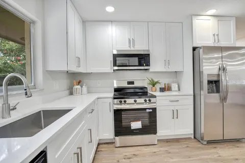 a kitchen with stainless steel appliances granite countertop a sink stove and refrigerator