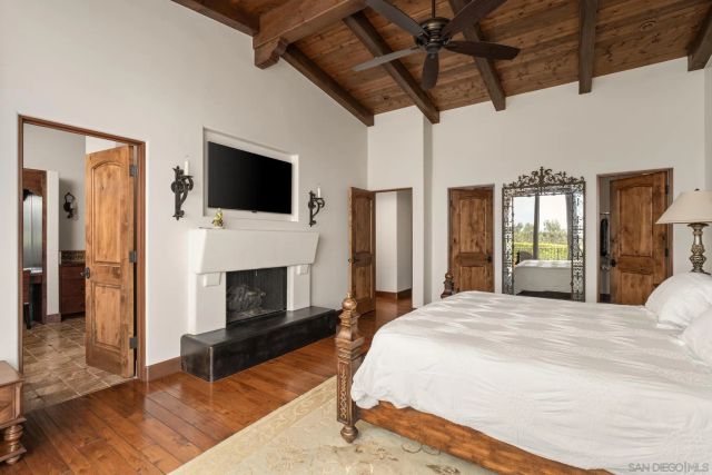 a spacious bedroom with a bed and a flat screen tv