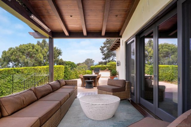 a living room with patio furniture and garden view