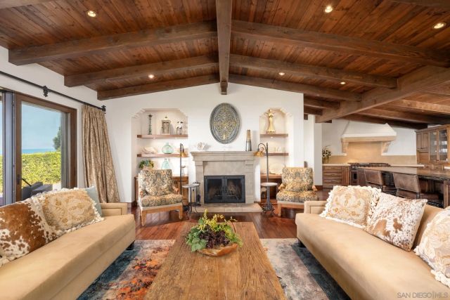 a living room with furniture a fireplace and a large window