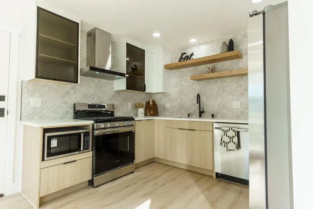 a kitchen with stainless steel appliances granite countertop a stove and a refrigerator