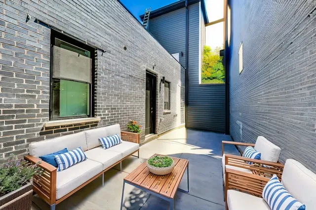 a backyard of a house with couches and a potted plant
