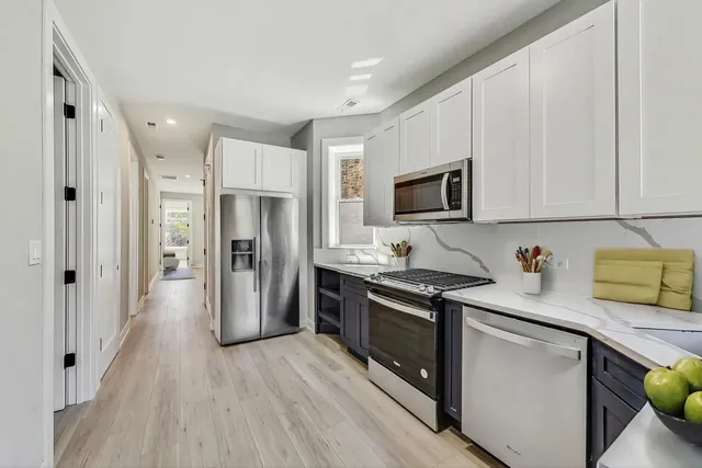 a kitchen with stainless steel appliances a stove microwave and refrigerator