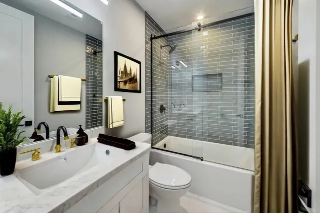 a bathroom with a sink a toilet a mirror and shower