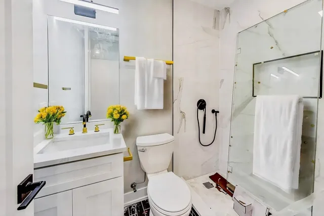 a bathroom with a toilet sink shower and mirror