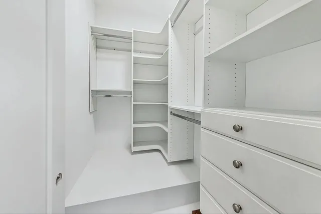a view of walk in closet with empty racks