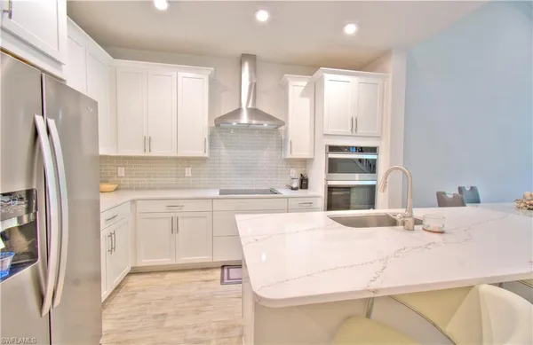 a large kitchen with cabinets a sink a window and stainless steel appliances
