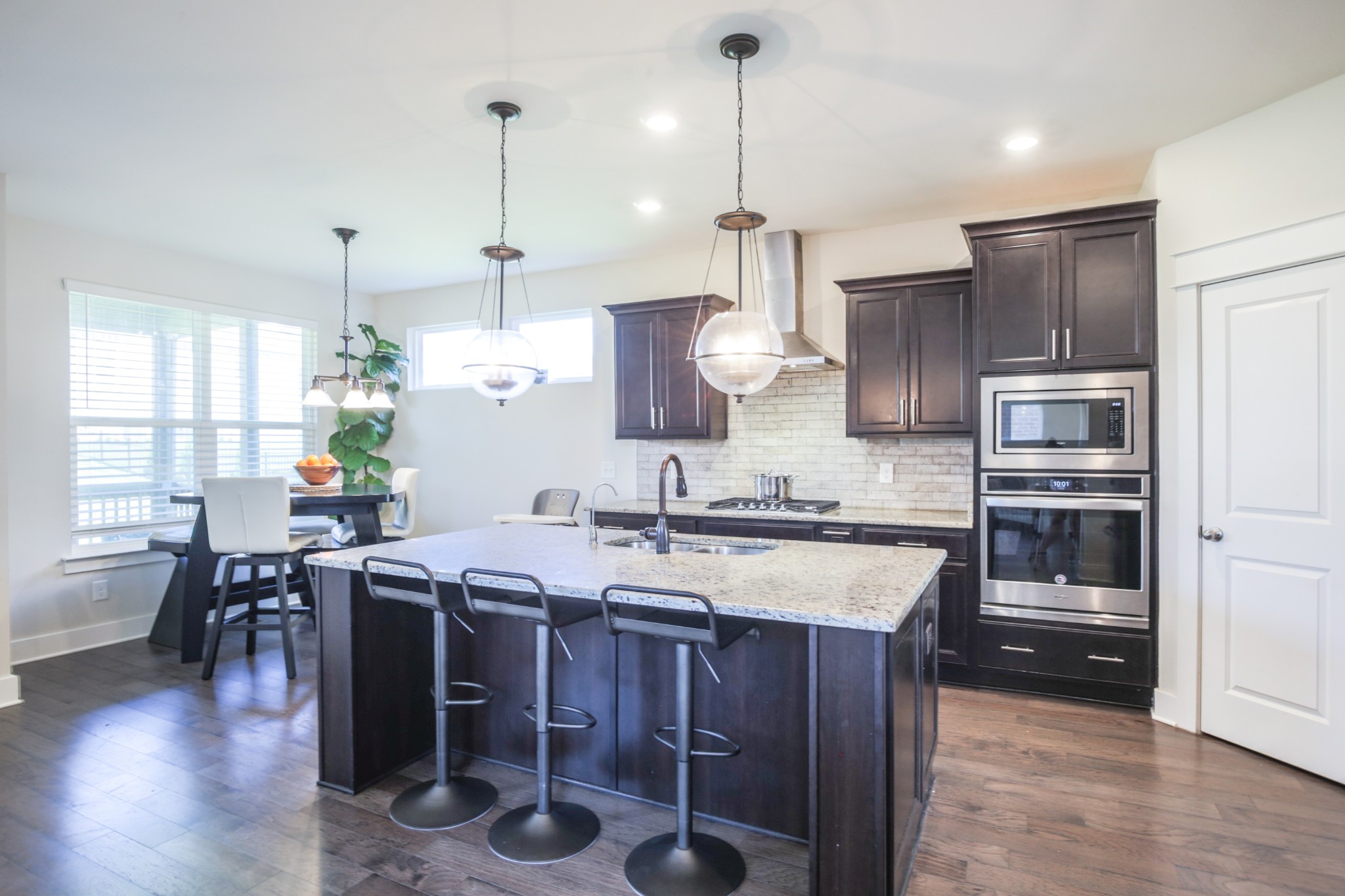 619 Beamon Drive Franklin, TN 37064 - Photo 14 of 43 a kitchen with stainless steel appliances granite countertop a stove refrigerator a dining table and chairs with wooden floor
