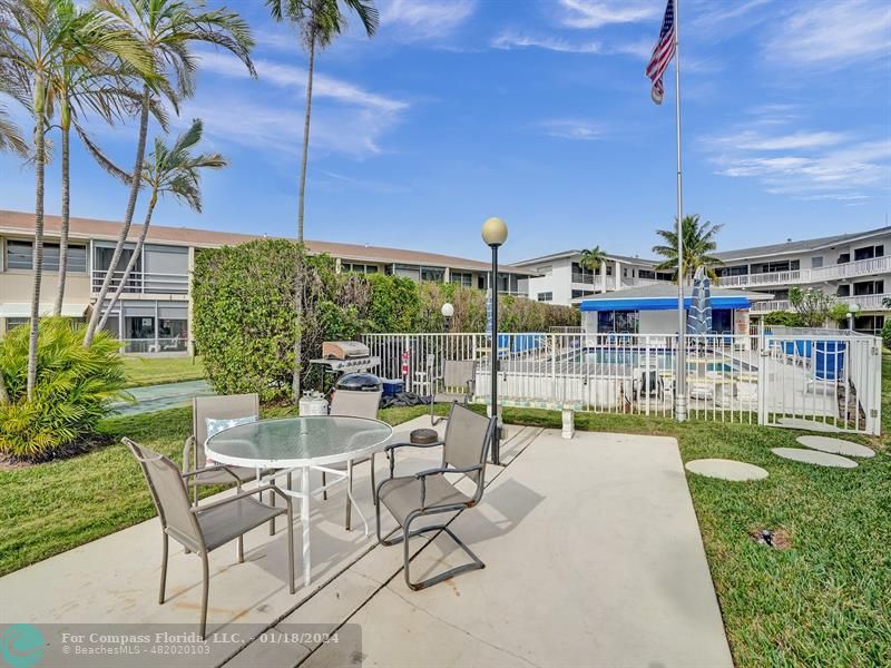 600 Pine Drive, Unit 106 Pompano Beach, FL 33060 - Photo 15 of 15 a view of a patio with a table chairs and a garden