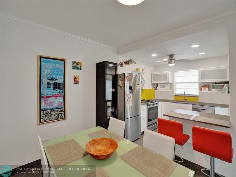 600 Pine Drive, Unit 106 Pompano Beach, FL 33060 - Photo 6 of 15 a kitchen with stainless steel appliances kitchen island granite countertop a refrigerator a stove a microwave oven with a dining table and chairs