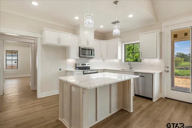 a kitchen with a sink window and cabinets