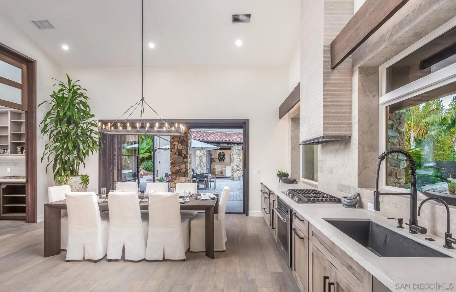 1240 Berryman Canyon Encinitas, CA 92024 - Photo 11 of 66 a kitchen with stainless steel appliances kitchen island a large counter top a sink a stove and a wooden floors